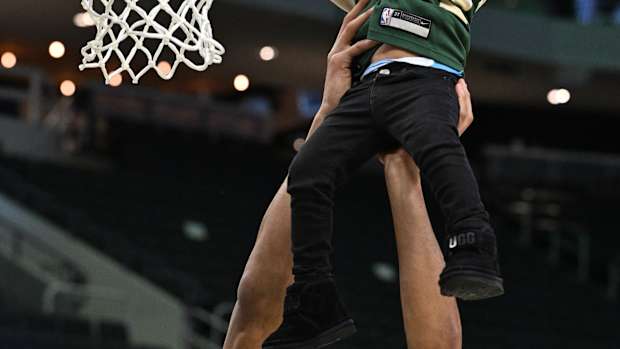 Milwaukee Bucks forward Giannis Antetokounmpo (34) lifts his middle son Maverick up to dunk 